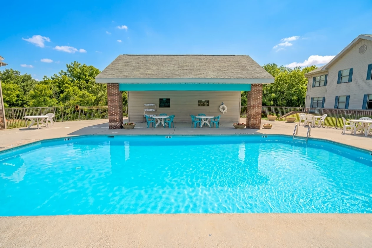 a pool with a gazebo and tables