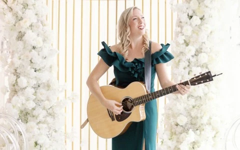 a woman in a green dress playing a guitar