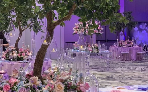 a table set up with a tree and flowers