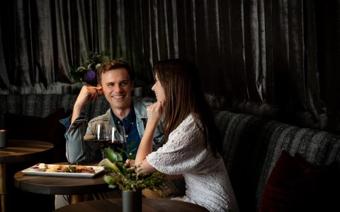 couple chatting over dinner with wine