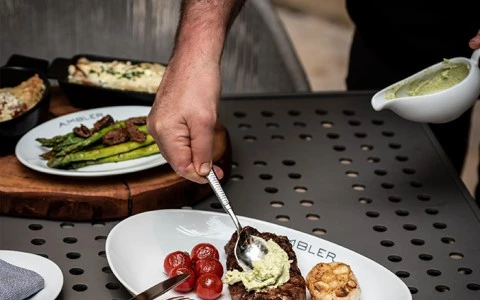 chef putting herb butter over a piece of steak