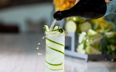 drink being poured onto a tall glass