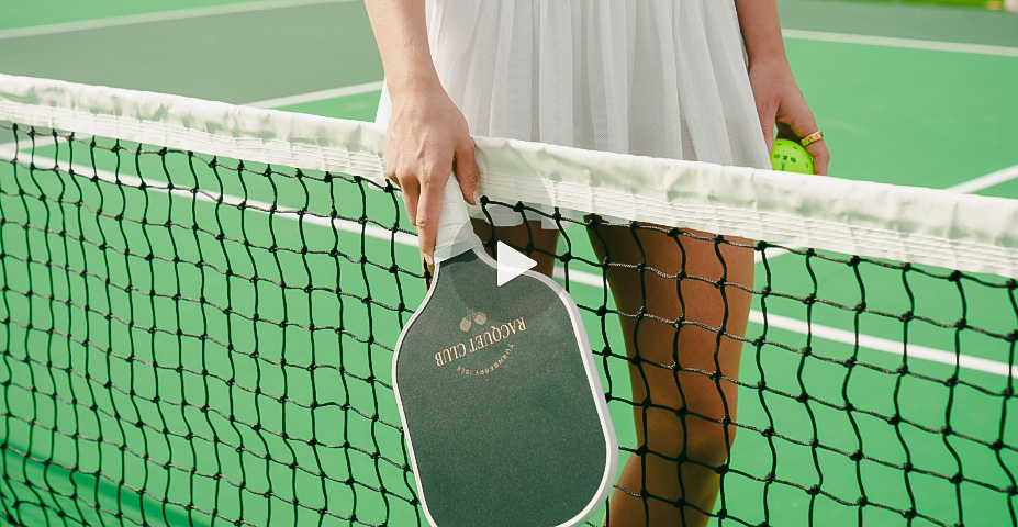 a person holding a paddle over a tennis net