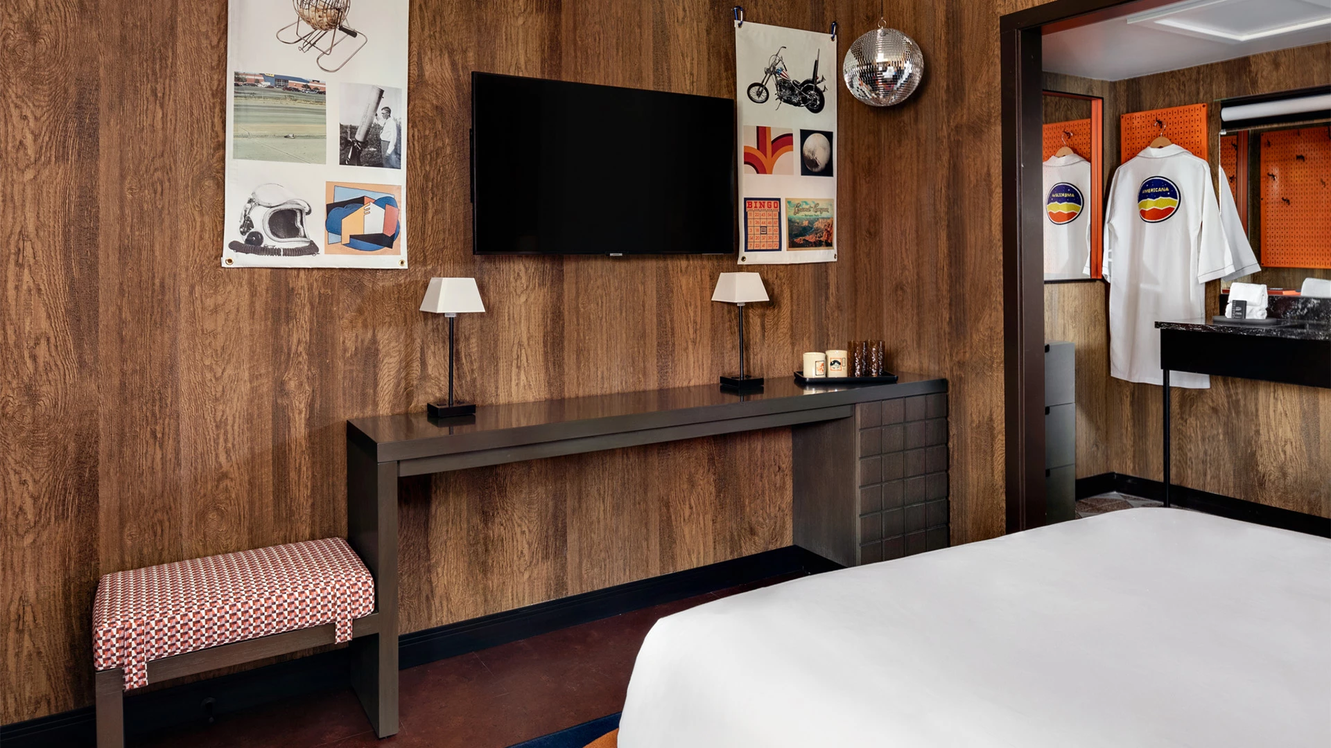 a room with a bed and a desk with a television on it