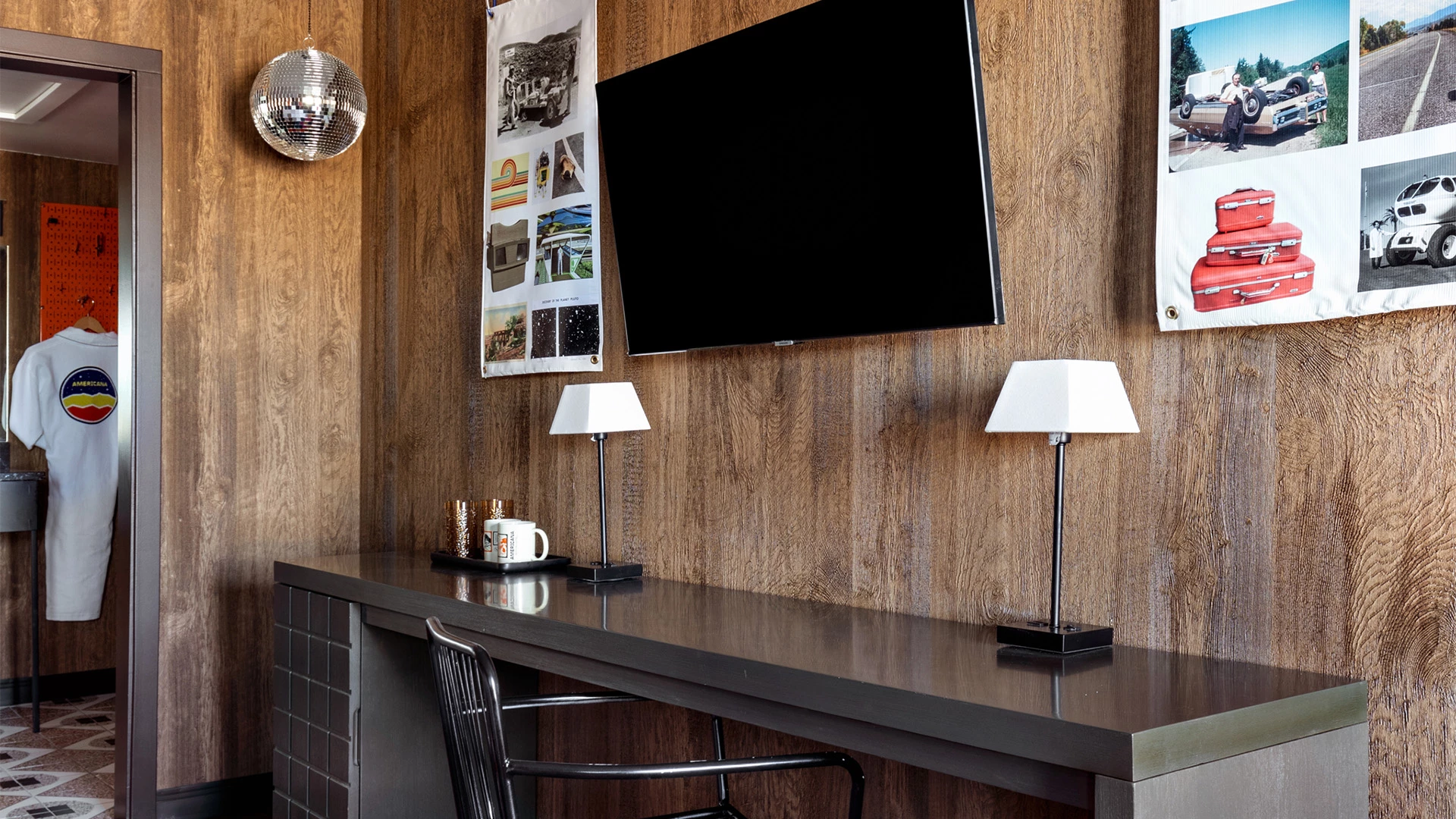 a room with a tv and a table with a lamp on it