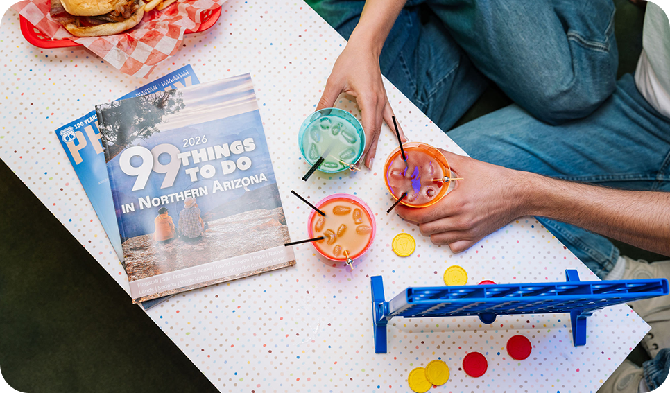 a person holding drinks with straws on a table