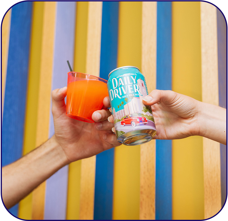 a hand holding a drink and a can