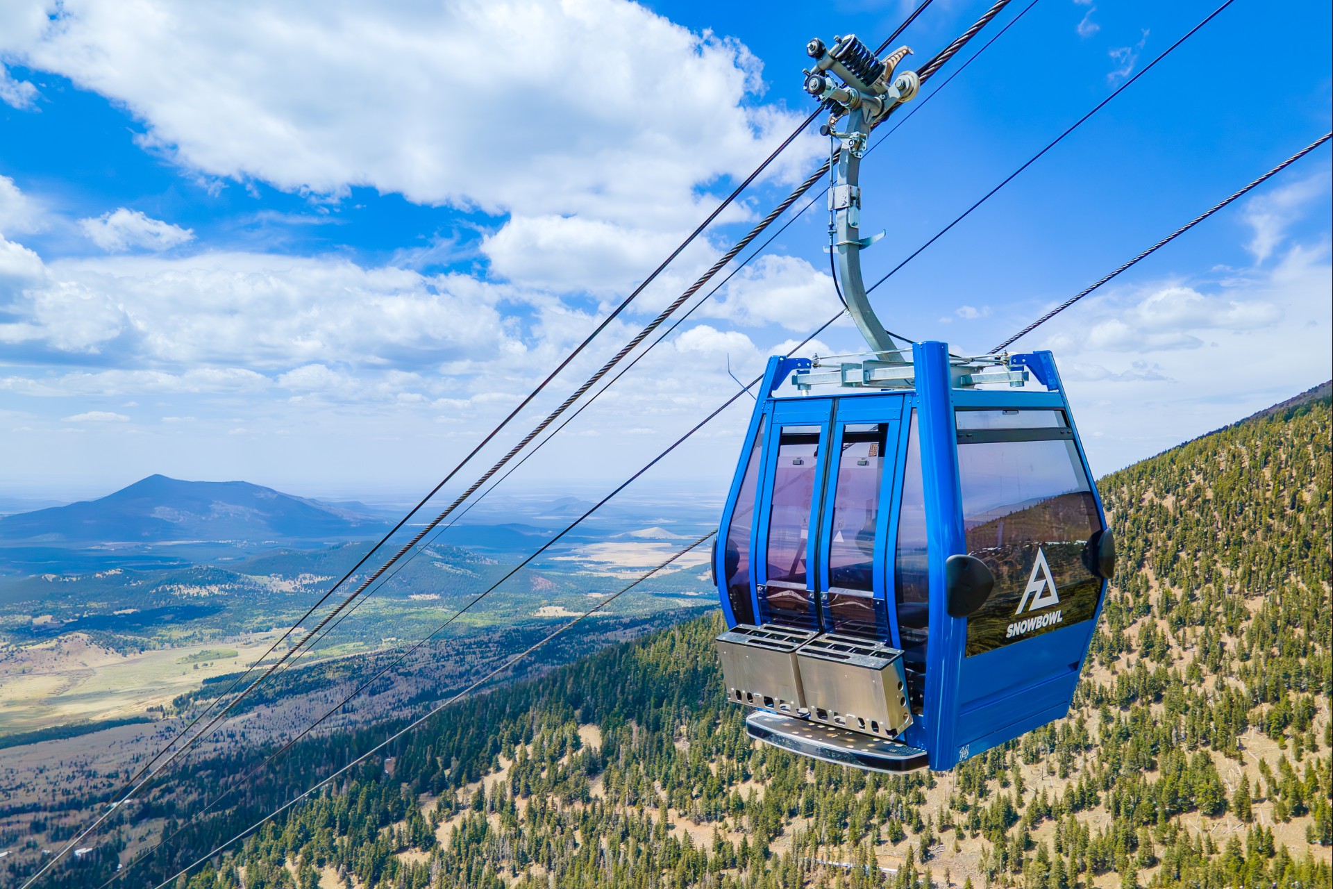 a gondola with a view of a forest and mountains