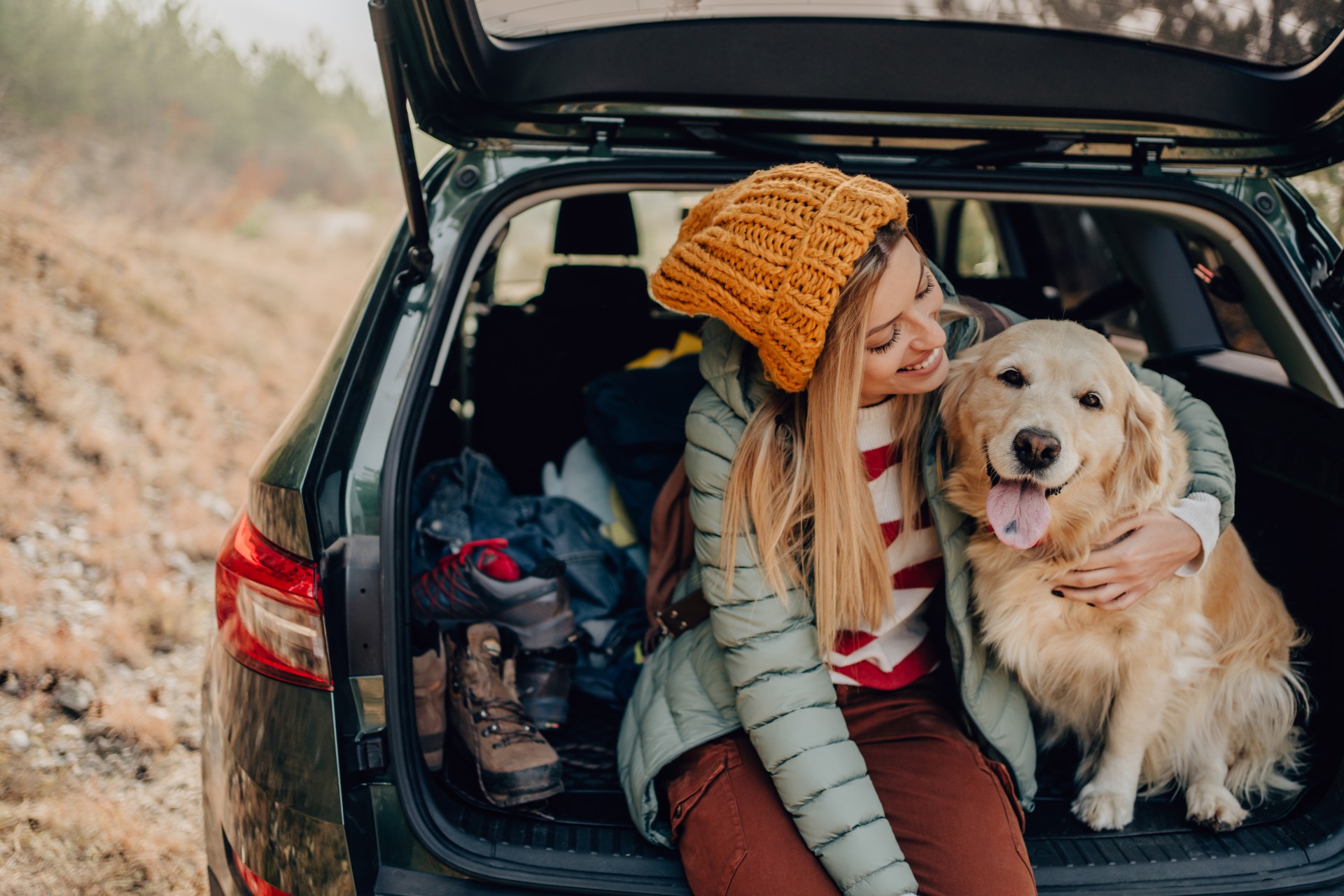 a woman and a dog in the back of a car