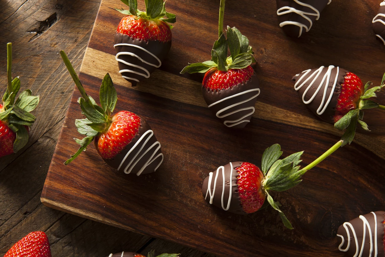 chocolate covered strawberries on a wooden board