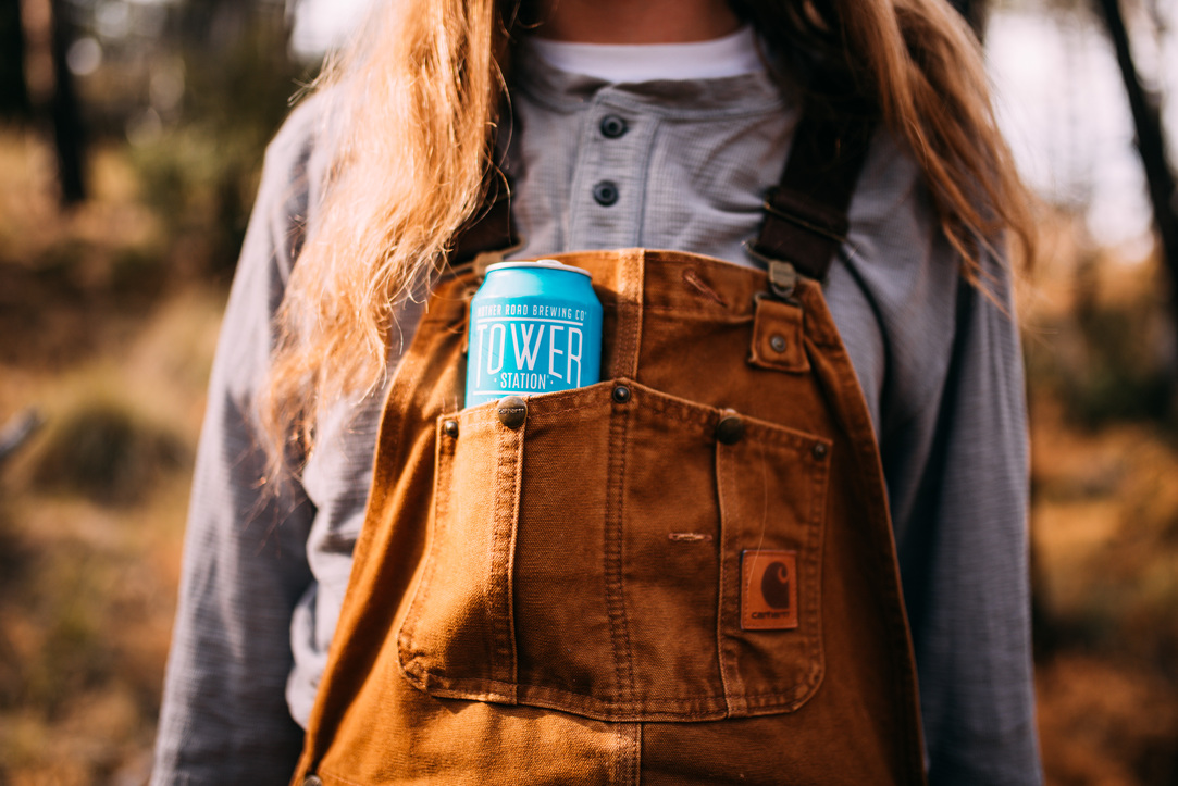 a person wearing overalls with a blue can in the pocket
