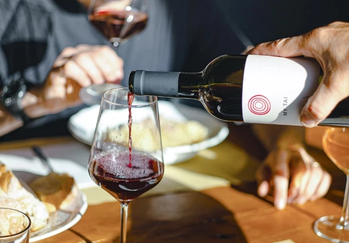 a person pouring wine into a glass