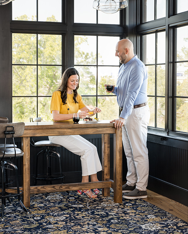 a man and woman sitting at a table with wine