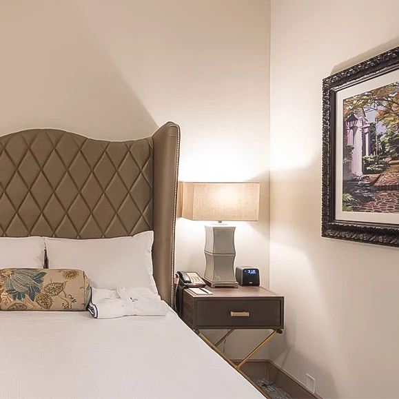 a bed with a lamp and a picture on the wall