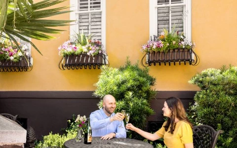 couple sitting and cheering with a glass of champagne on the patio