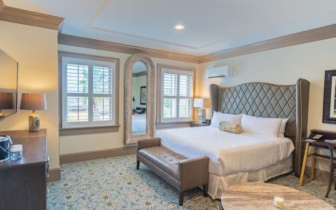 queen bed with a headboard and a furniture by the bottom of the bed