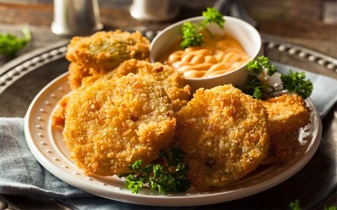a plate of fried food with dipping sauce