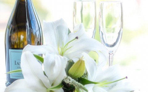 a wedding bouquet with two champagne glasses and a bottle of champagne