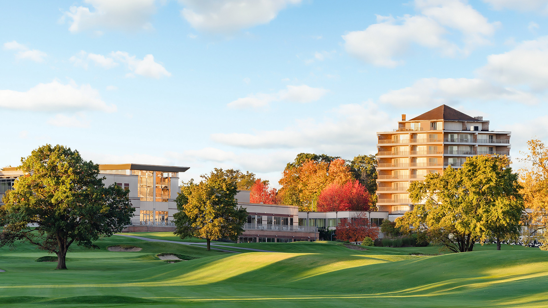 a golf course with trees and buildings