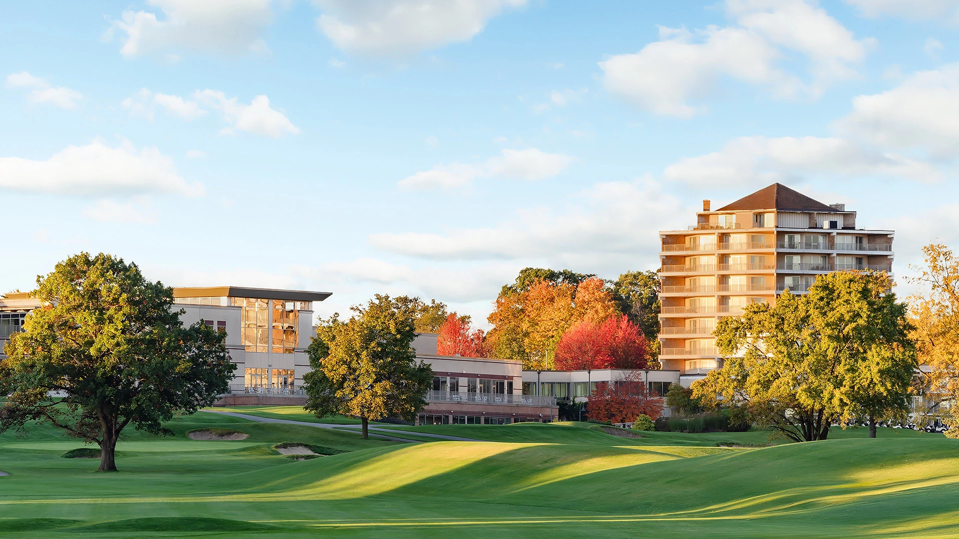 a golf course with trees and buildings
