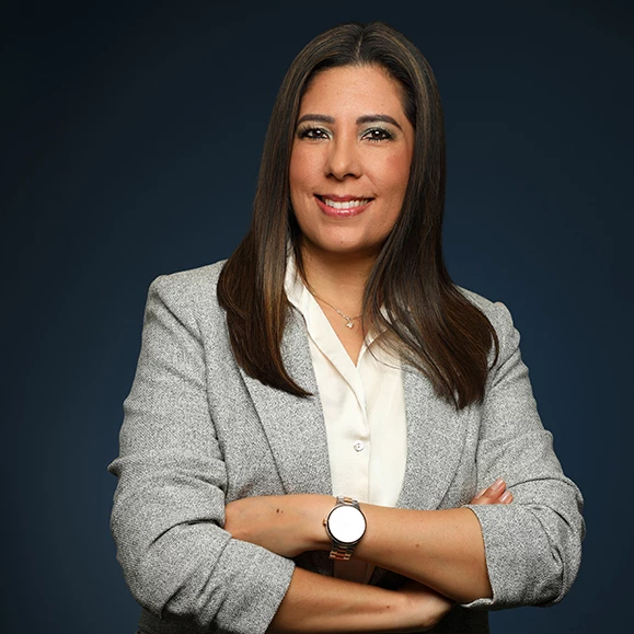 a woman with long hair wearing a grey suit and white shirt
