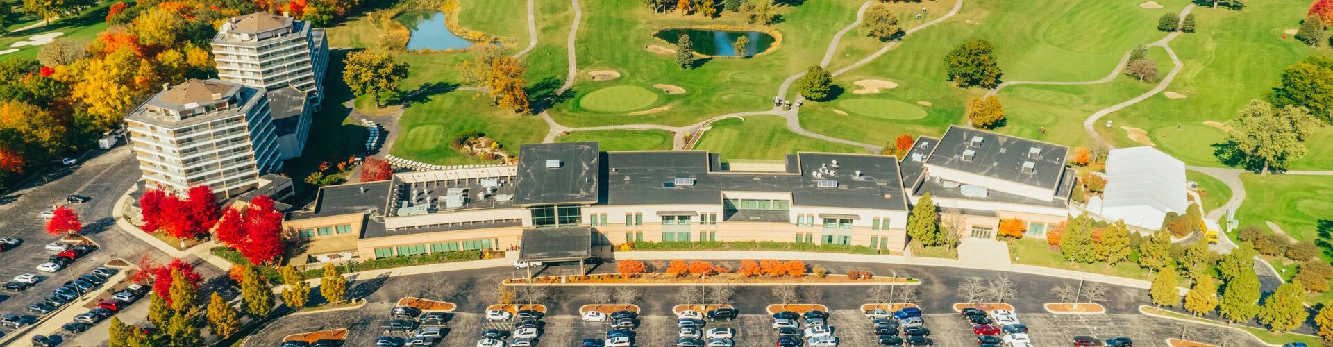 a parking lot with cars and a golf course