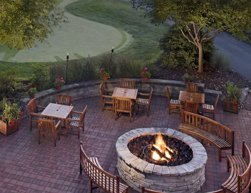 a fire pit with chairs and tables on a patio