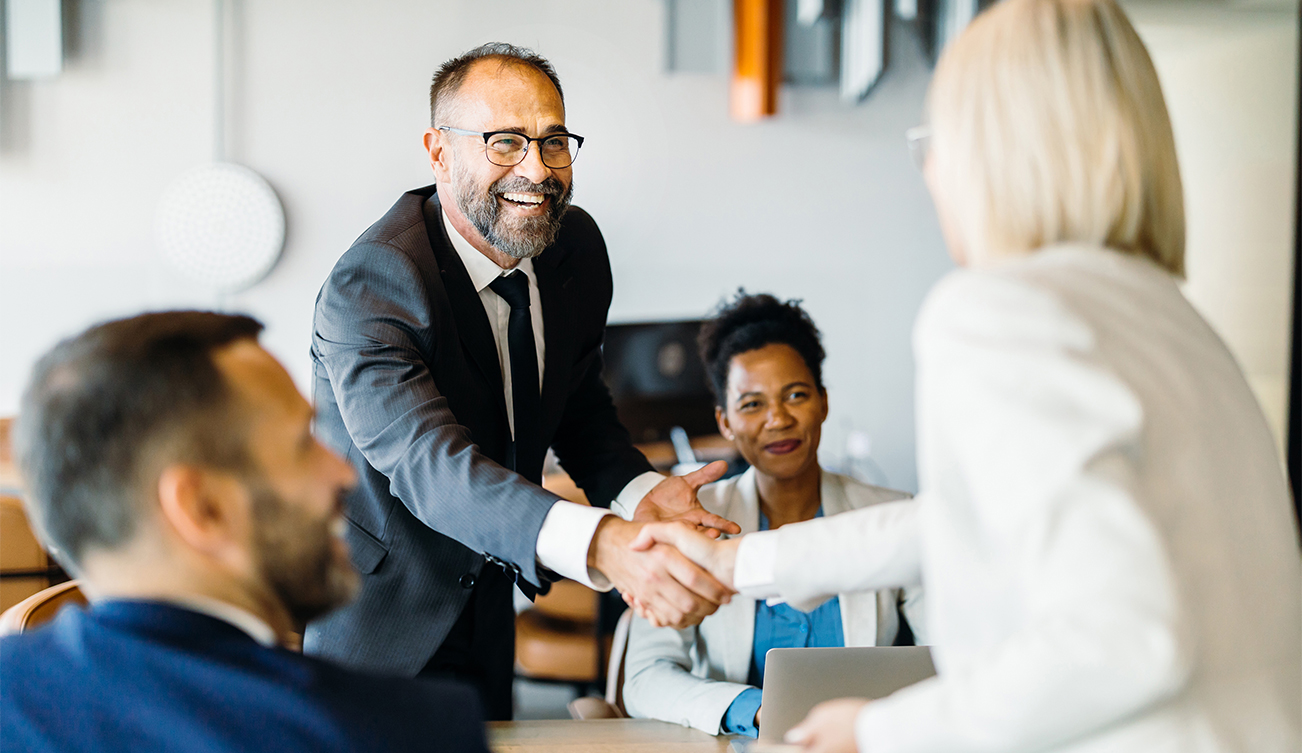 a man shaking hands with a woman in a meeting