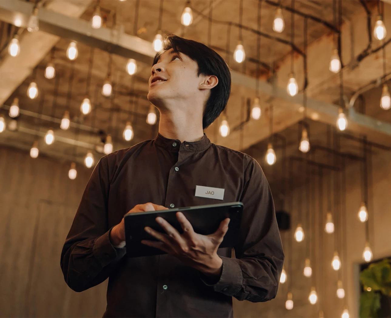 a man holding a tablet and looking up