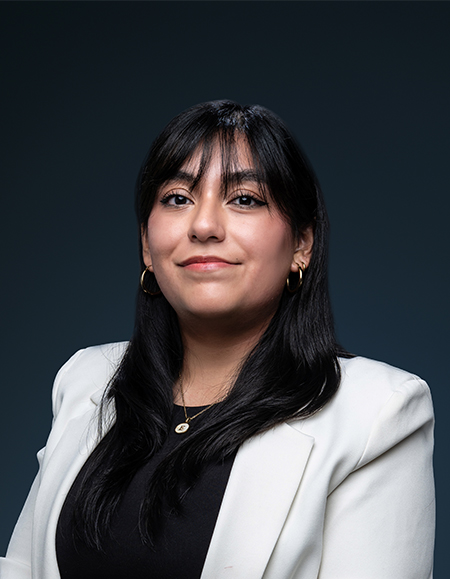 a woman with long black hair and a white blazer