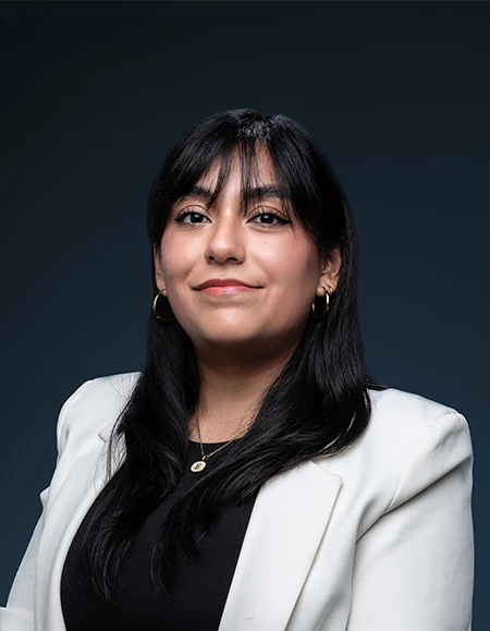 a woman with long black hair and a white blazer