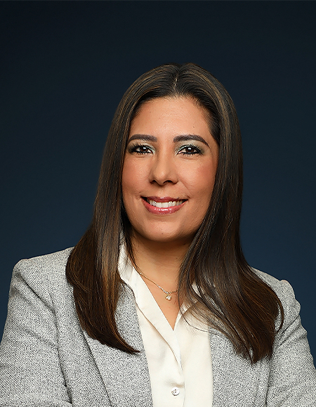 a woman with long brown hair wearing a grey suit