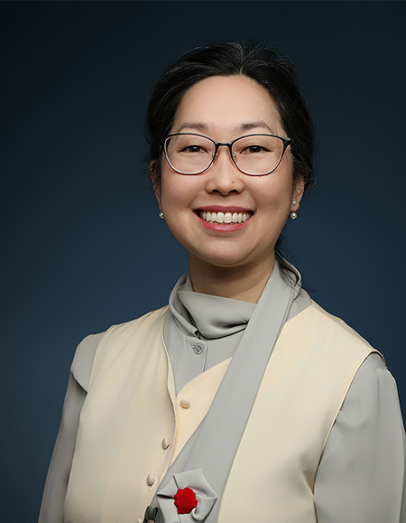 a woman wearing glasses and a beige vest