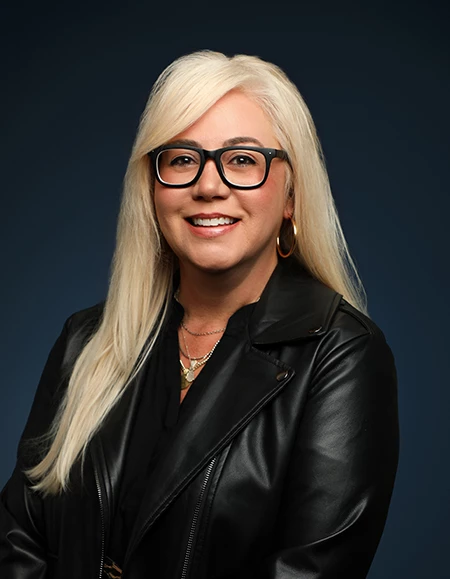 a woman wearing glasses and a leather jacket