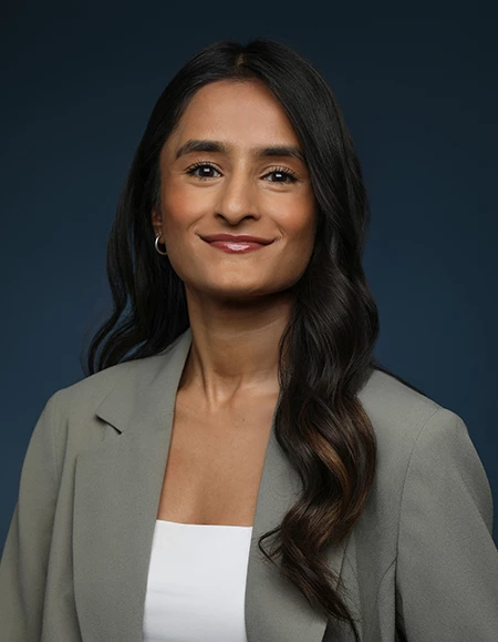 a woman with long hair wearing a grey jacket