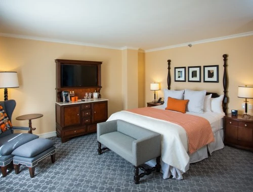 bedroom with dark furniture and orange accents on the bed