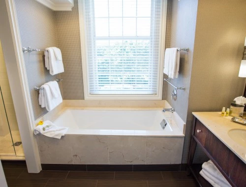 bathtub next to a window with towel racks