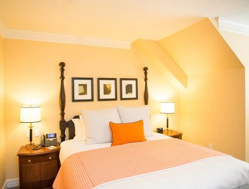 king bed with yellow wall and orange accents