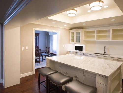 large kitchen area with marble counter top and stools