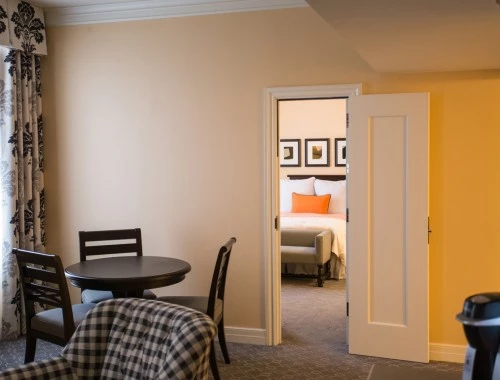 interior view of a hotel room with yellow walls and a view of the bedroom