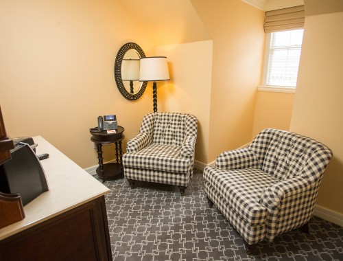 two black and white chairs with a lamp in the corner