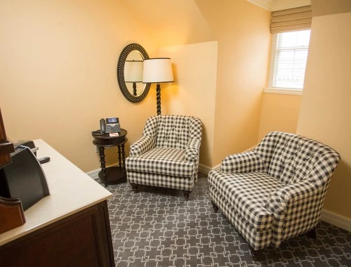 two black and white chairs with a lamp in the corner