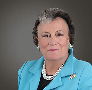a woman wearing a blue jacket and pearl necklace