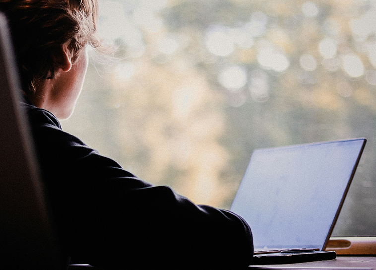 a woman sitting at a desk with a laptop
