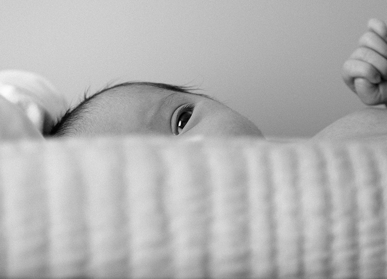 a baby's face looking over a blanket