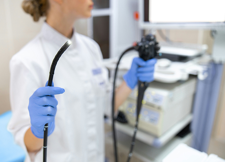 a woman wearing gloves holding a medical device