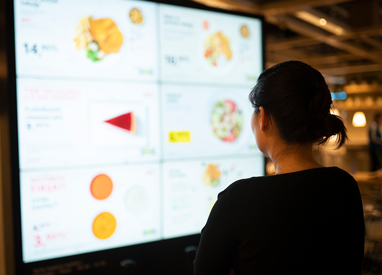a woman looking at a large screen