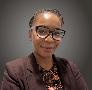 a woman wearing glasses and a brown jacket