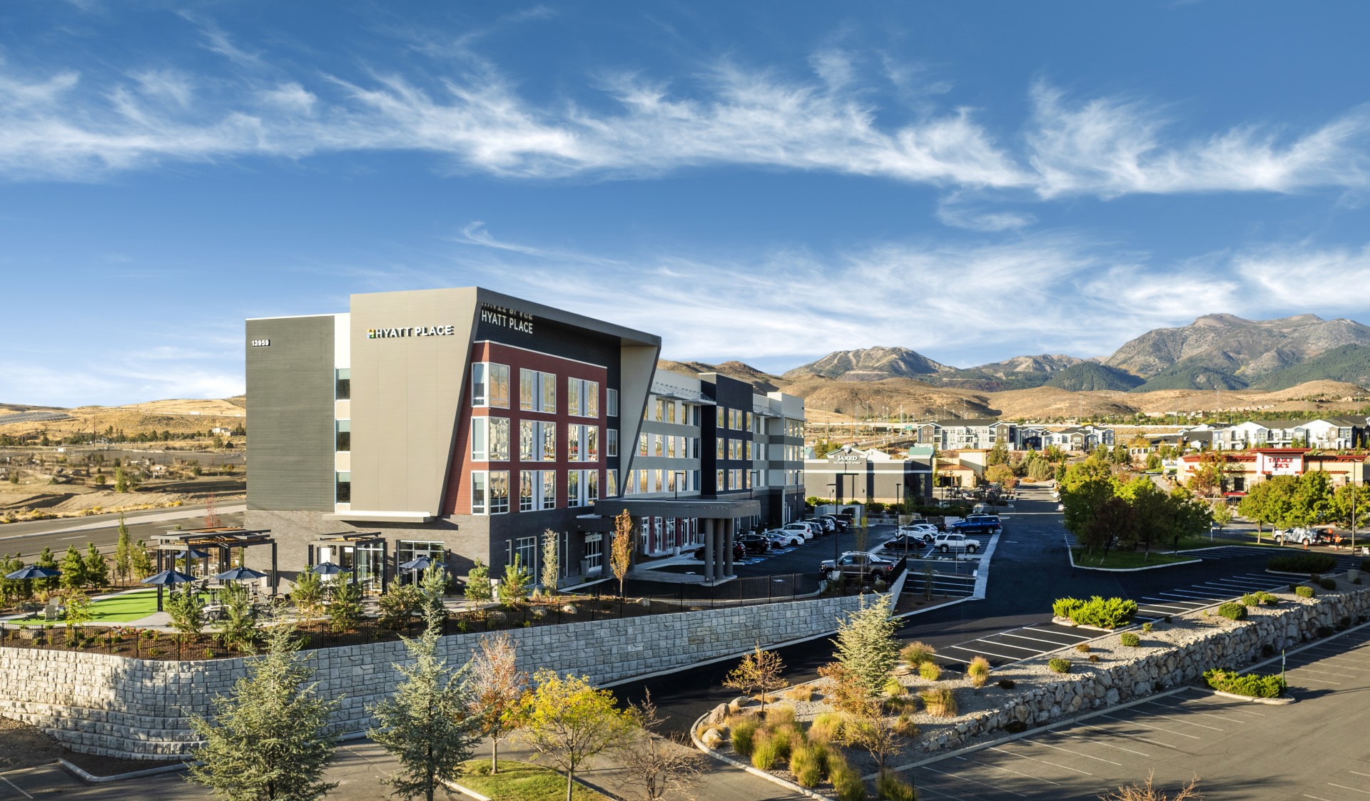 a building with parking lot and mountains in the background
