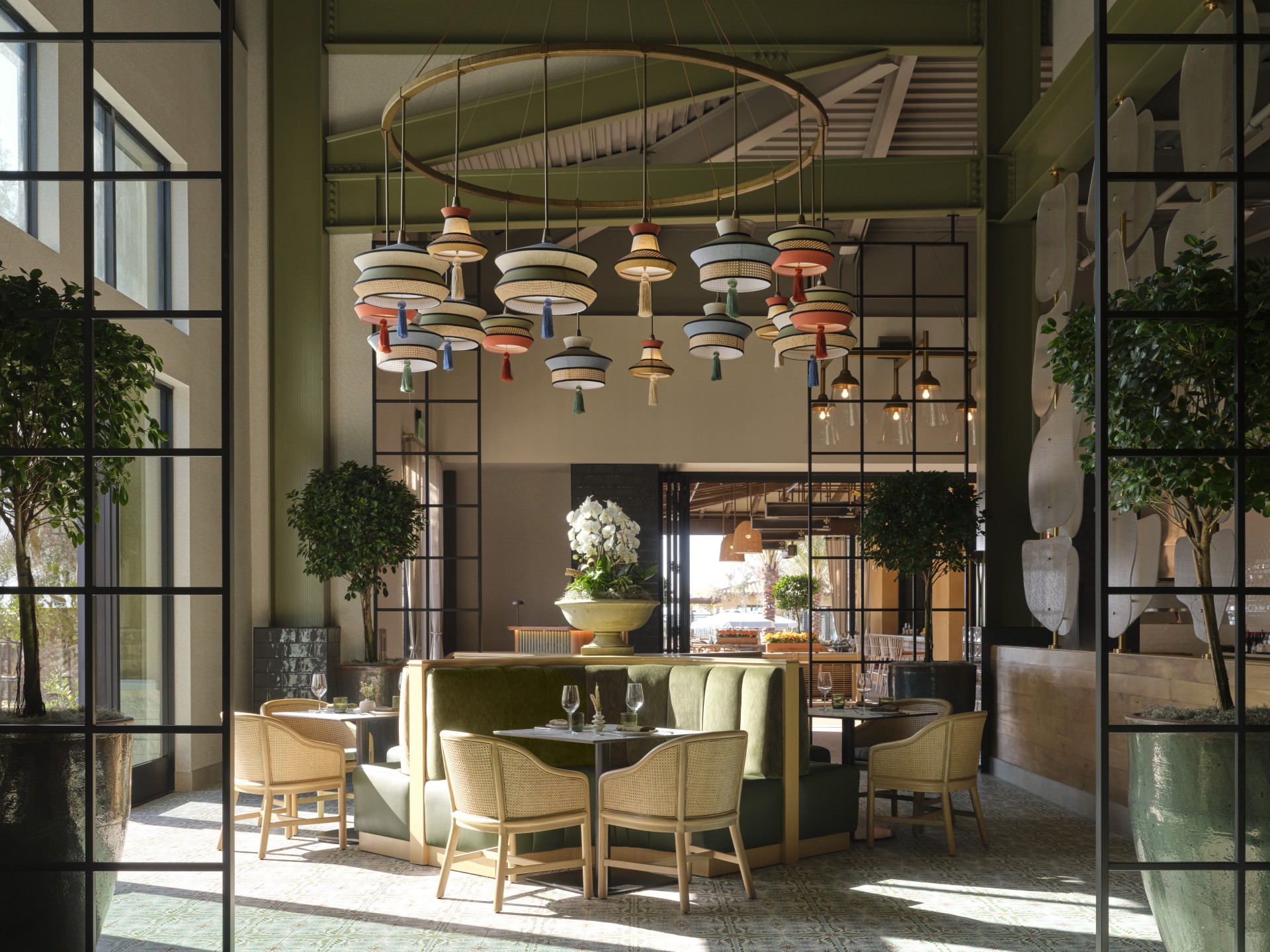 a room with a chandelier and tables and chairs